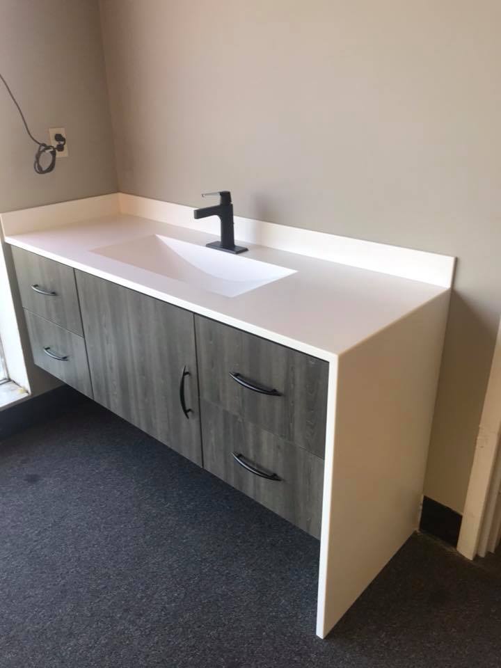 a sink with cabinets and white surface