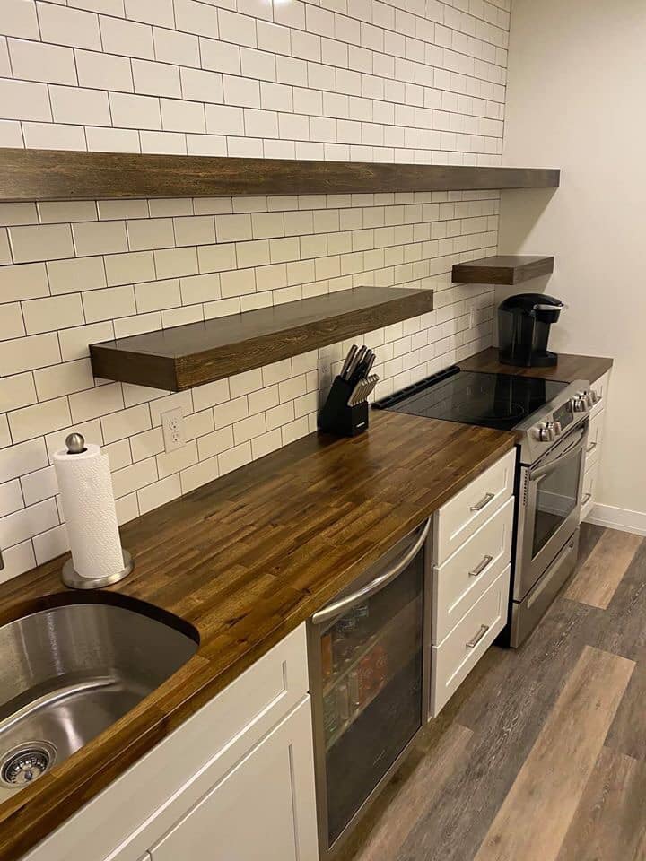 a kitchen with wooden countertop and shelfs