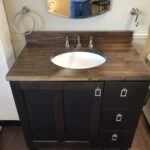Madera Coffee Vanity Top with white sink inset over dark wood cabinet. Bathroom innovations from AMI in Canton, Ohio