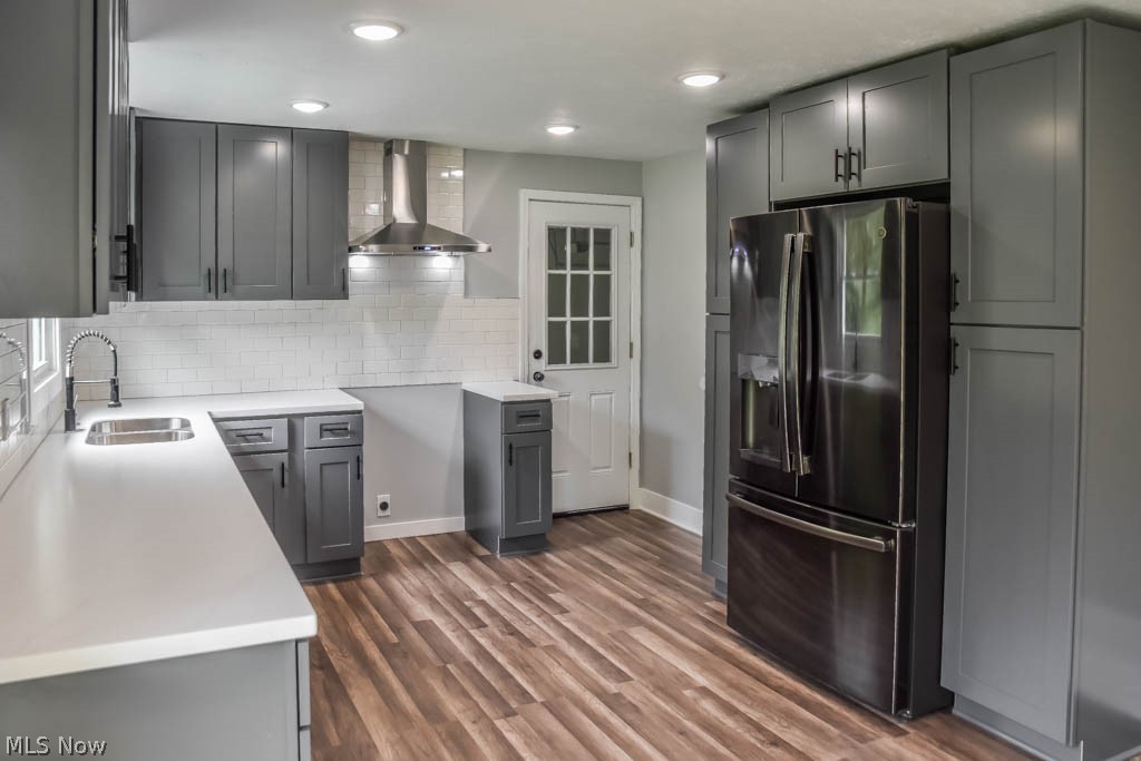 kitchen with grey cabinets, black refrigerator