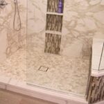 TYVARIAN CALCUTTA BROWN accented shower with GROUT FREE shower floor, walls, seat and niches.