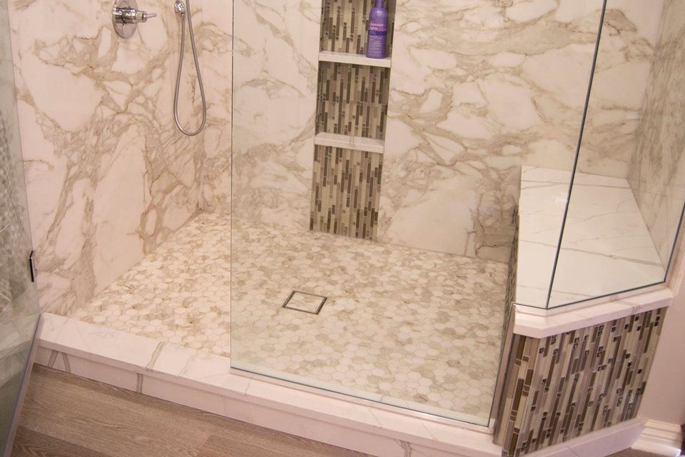 TYVARIAN Calcutta Brown accented shower with GROUT FREE shower floor, walls, seat and niches. American Marble Industries, AMI, Canton, Ohio.
