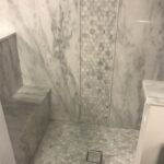 Shower features TYVARIAN Calcutta Gray with Inlay and Floor of Grout Free tile alternative. AMI in Canton, OHIO
