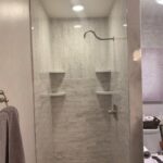 TYVARIAN STATUARY GRAY TILE with herringbone accents. Contact AMI in Canton, Ohio to customize your bathroom with no leak grout free tile alternatives.